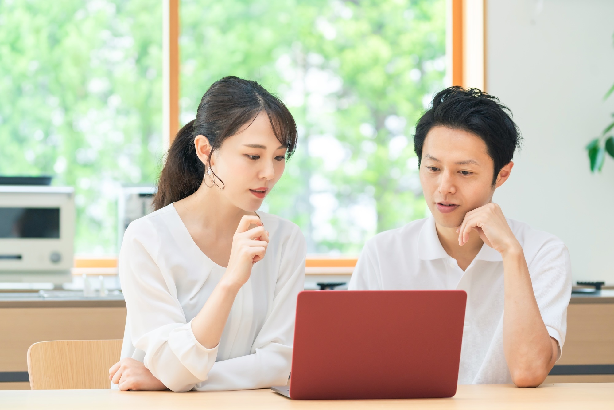 パソコンを見ながら話し合う夫婦