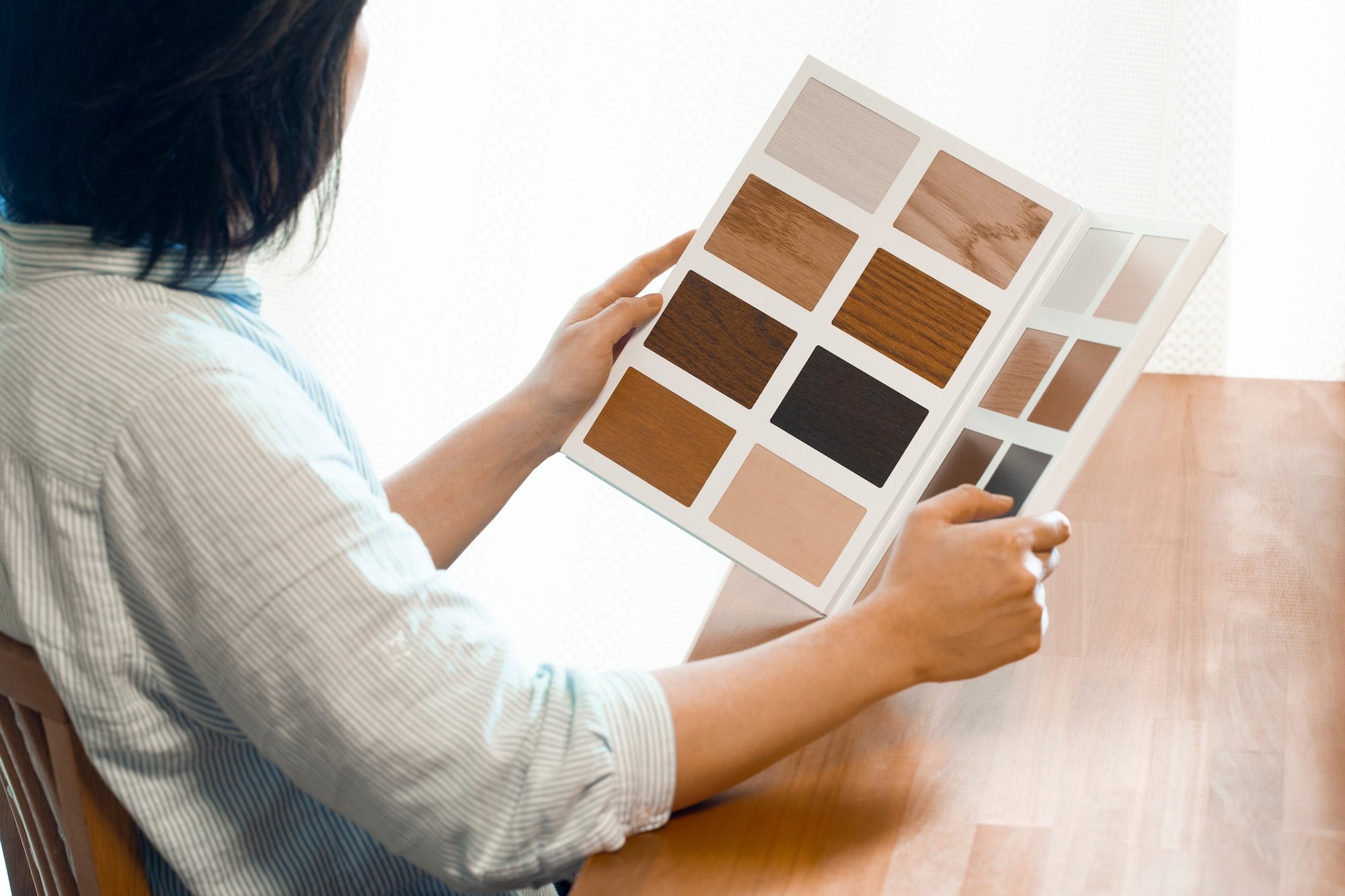 床材のサンプルを比較する女性