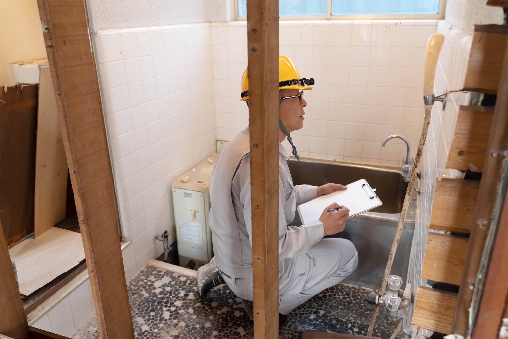 リフォームする浴室を調査する作業員