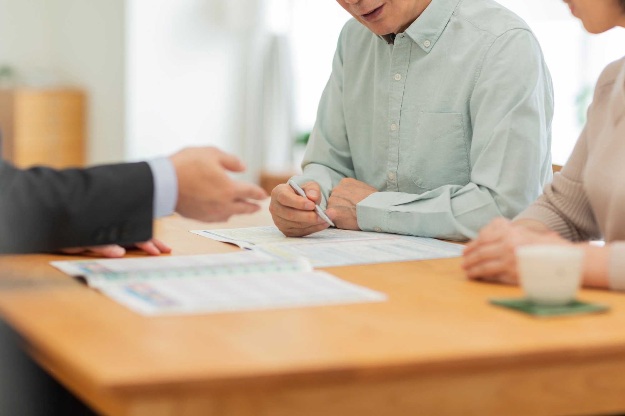 中年夫婦に説明するリフォーム会社の営業担当者