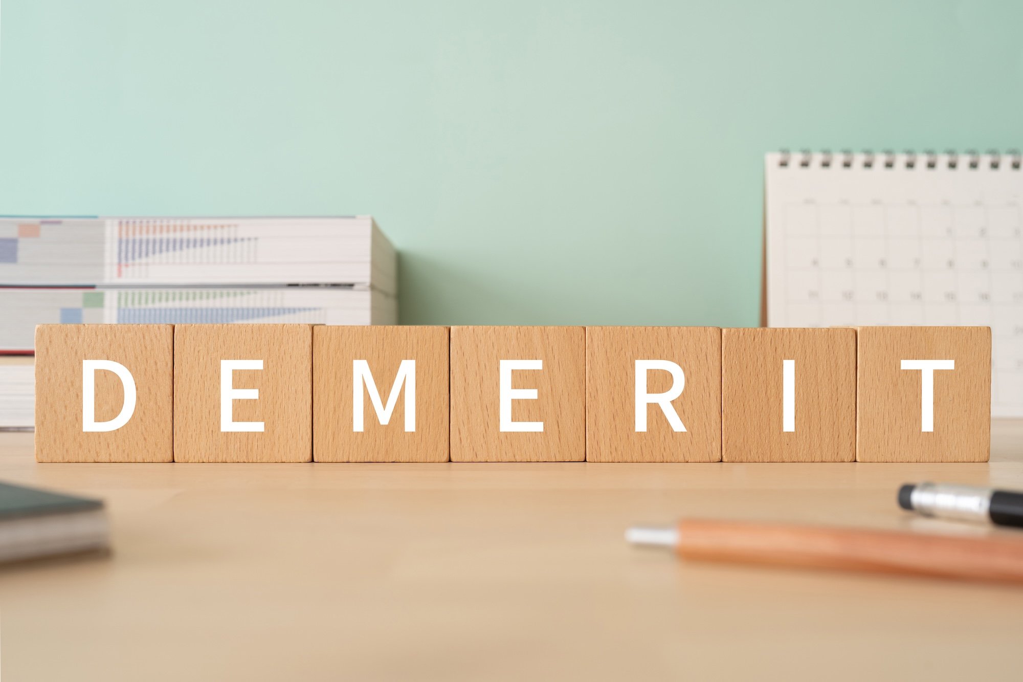 「DEMERIT」と書かれた積み木