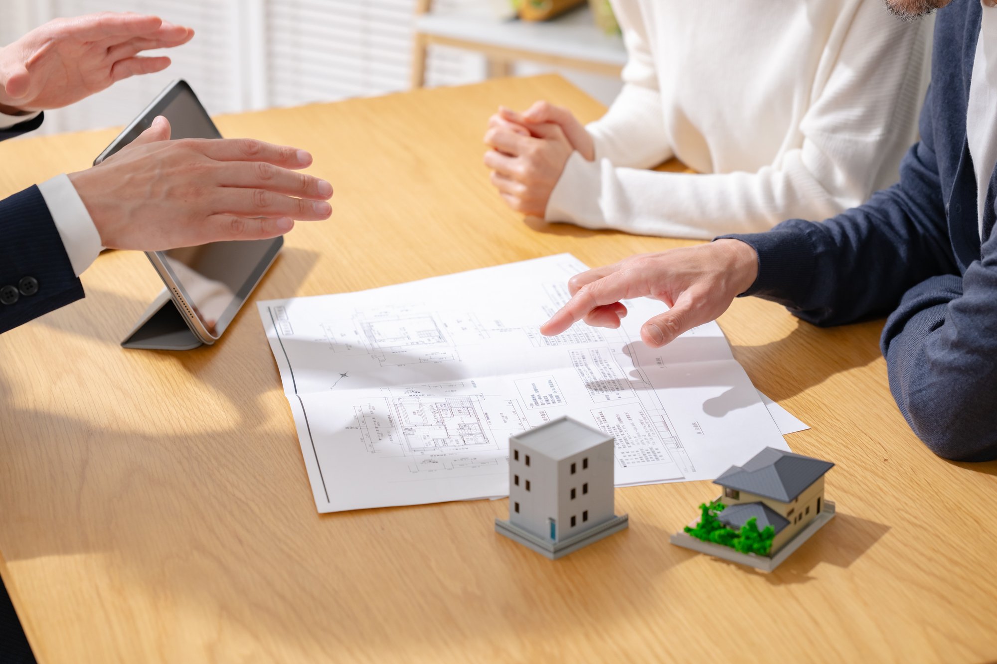 住宅検討中の夫婦と商談をする営業マン